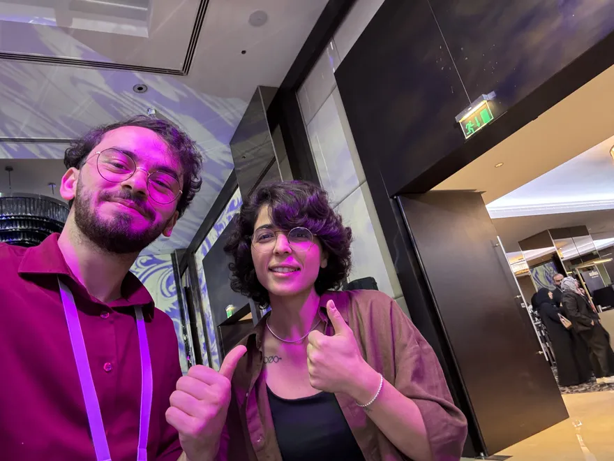 Meeting people at a conference, both giving a thumbs up