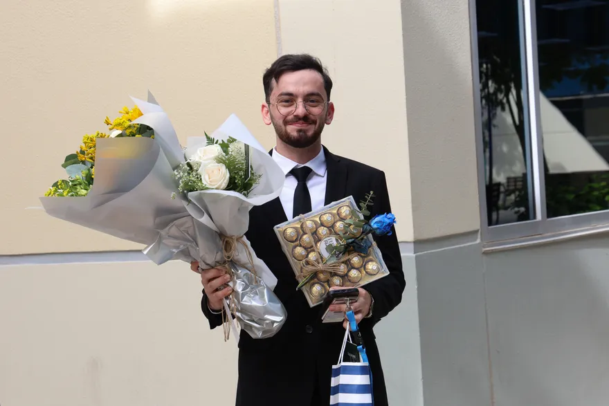 Holding flowers and chocolates after a capstone presentation